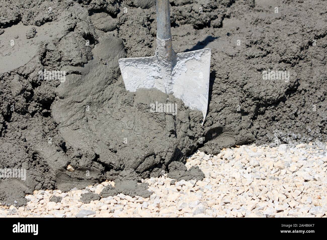 Dry cement covered shovel left in pile of fresh concrete ready for