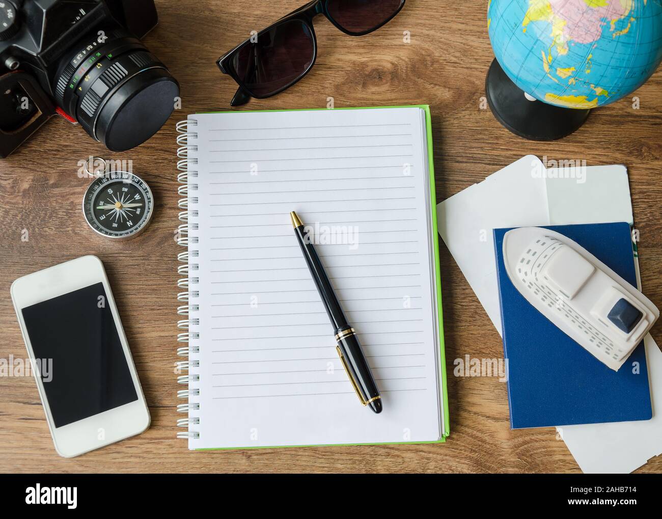 Notepad, credit cards, passport, ticket, luggage, phone and compass on a wooden background, set for travel planning Stock Photo