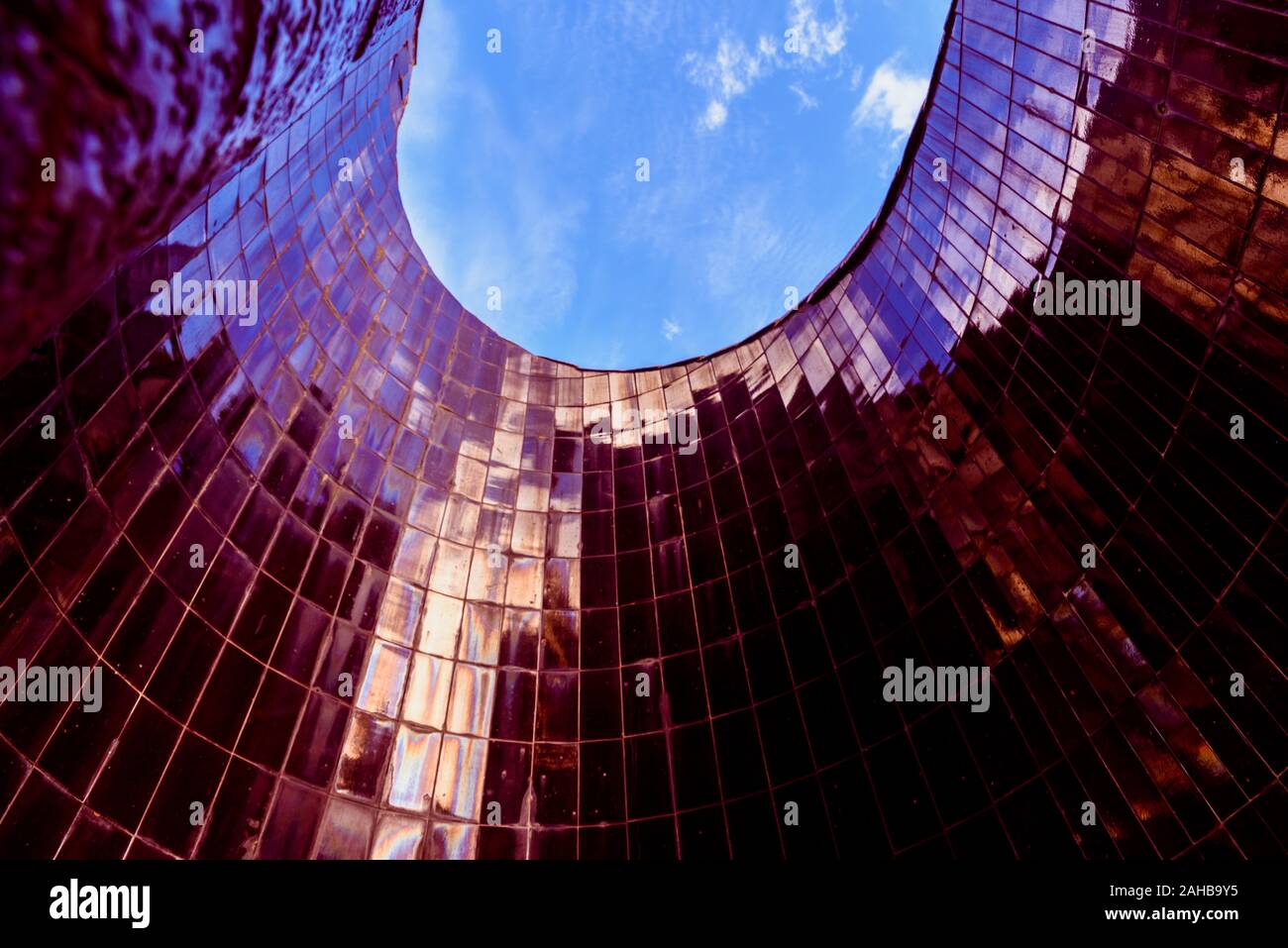 Conical smooth tile surface pointing to the blue sky with reflections ...