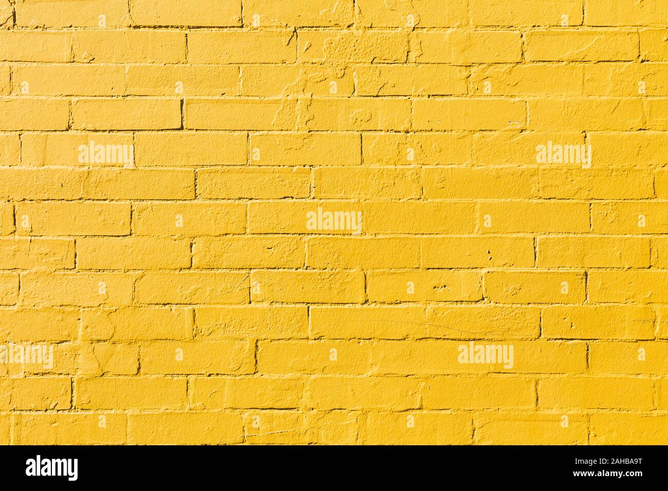 Retro bright yellow painted brick wall background texture Stock Photo