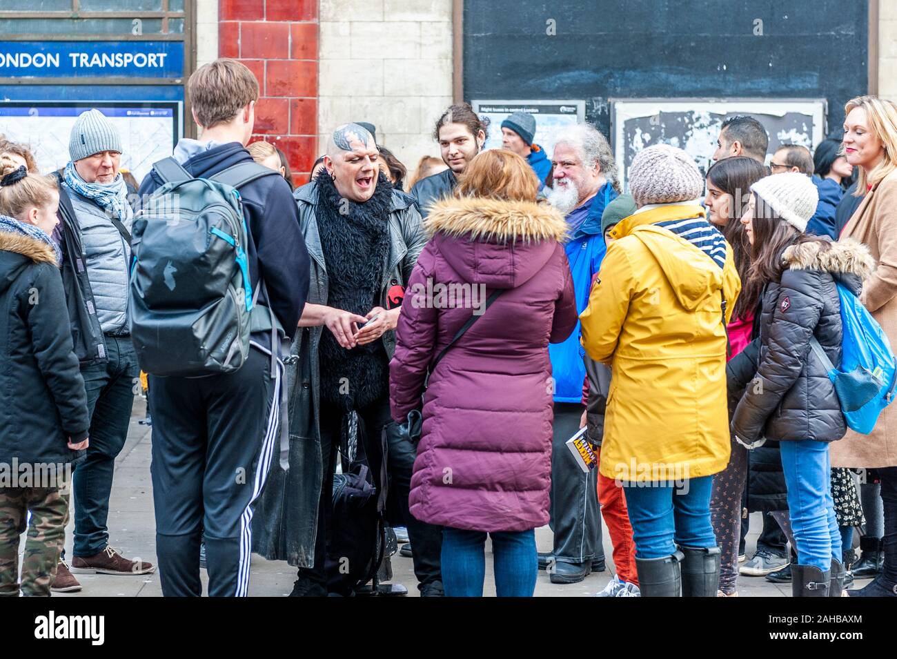 Man with tattoo on head speaks to tourists in Camden Town, London, UK. Stock Photo