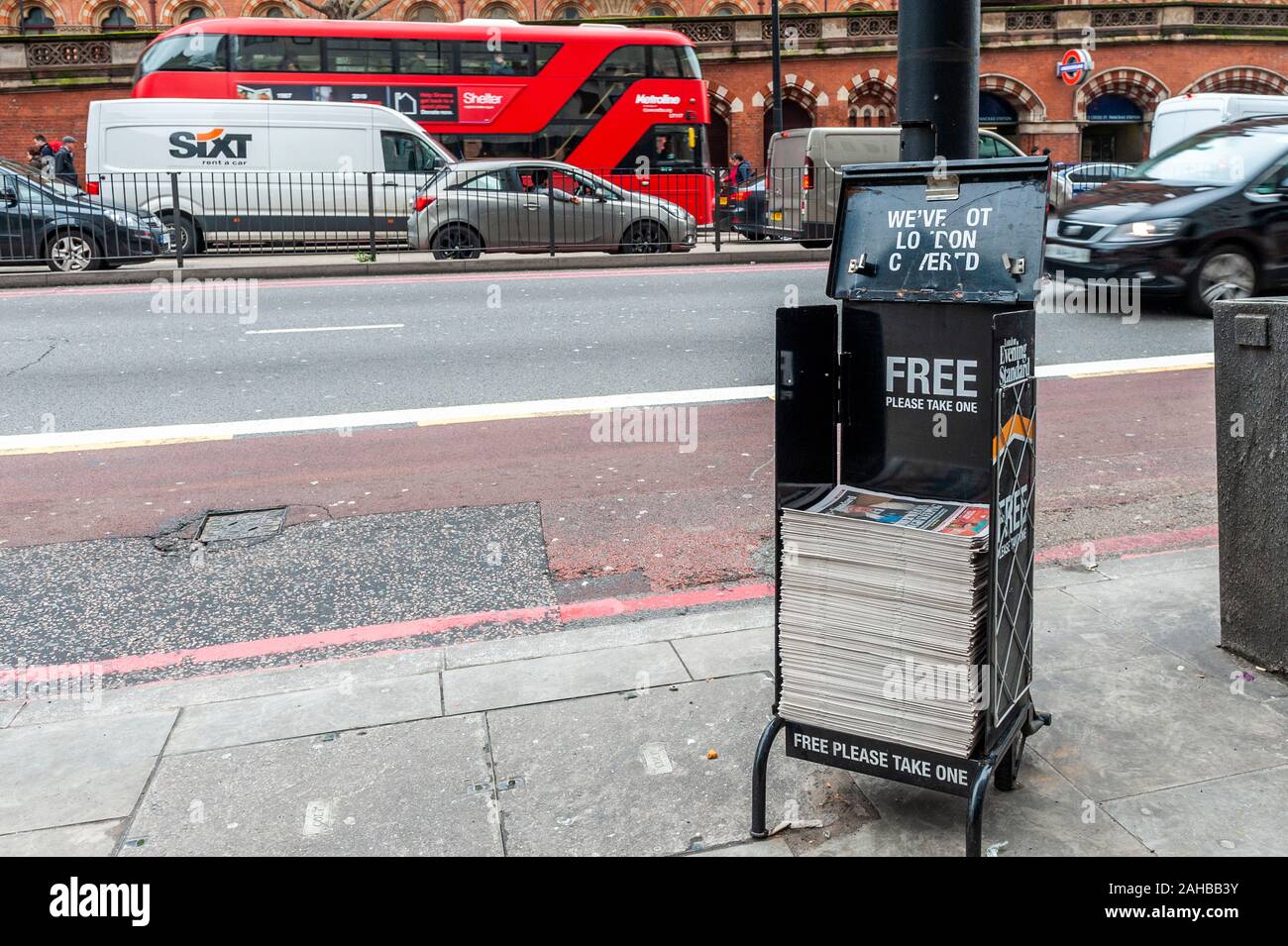 Pile of London Evening Standard Newspapers on a stand on a busy street in St.Pancras, London, UK. Stock Photo
