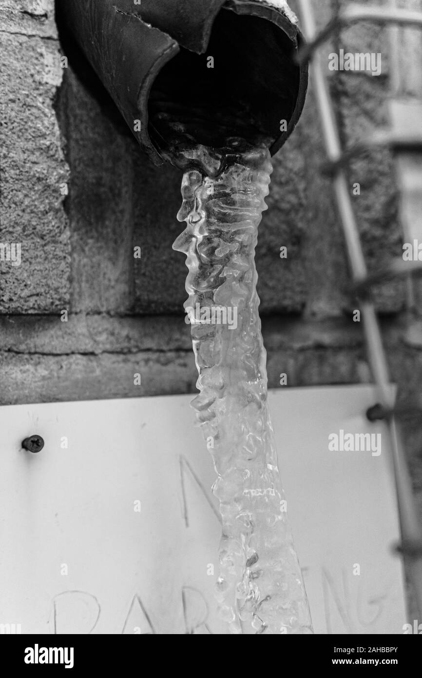 Frozen Icicle formed in building water pipe outside Stock Photo