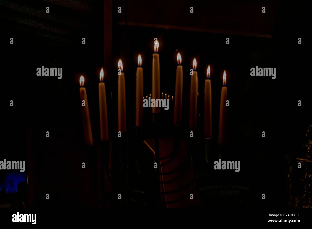 Menorah with lit candles in celebration of Chanukah. A symbolic candle lighting for the Jewish holiday of Hanukkah. The eighth and final night of Hanu Stock Photo