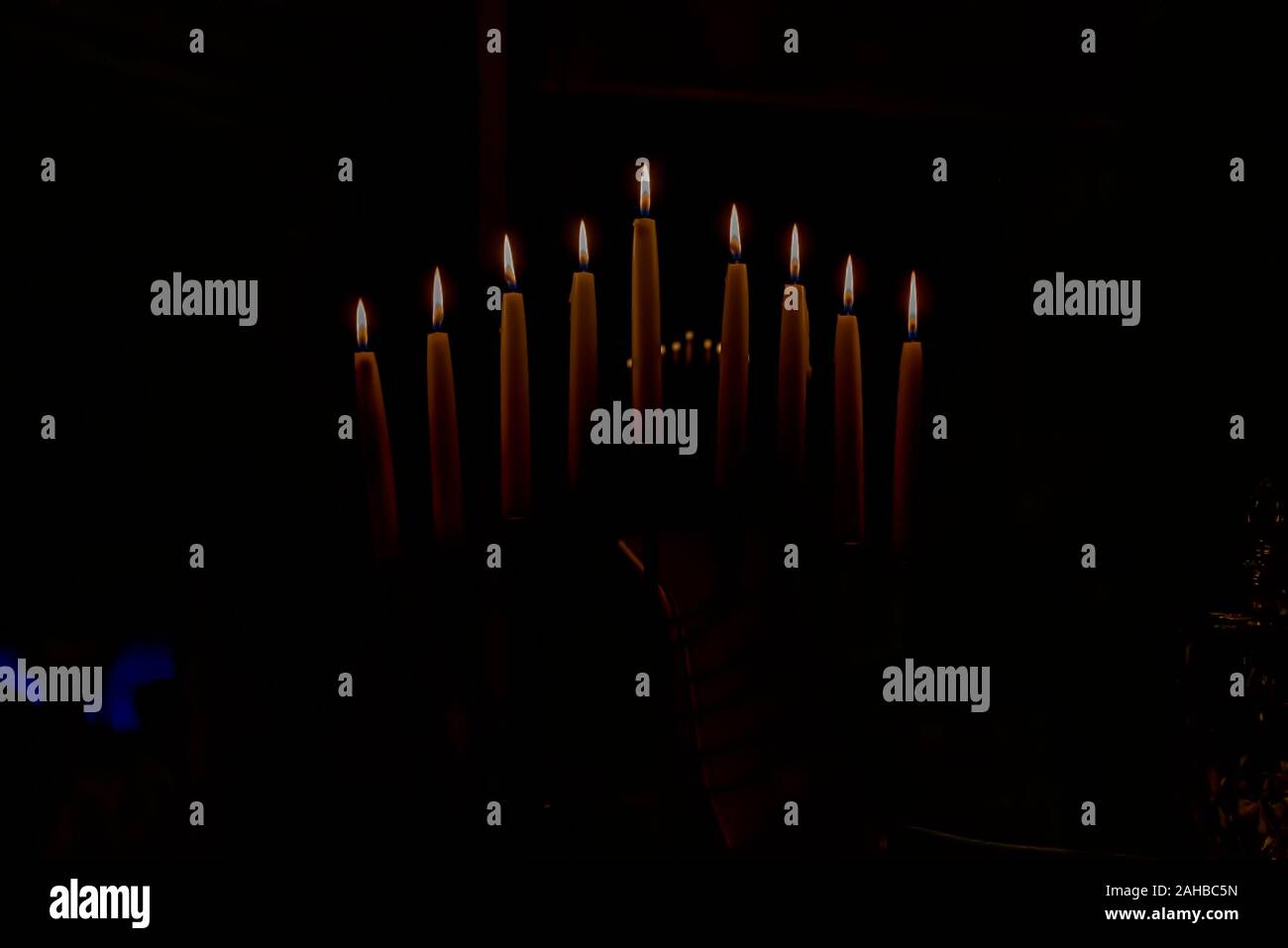 Menorah with lit candles in celebration of Chanukah. A symbolic candle lighting for the Jewish holiday of Hanukkah. The eighth and final night of Hanu Stock Photo