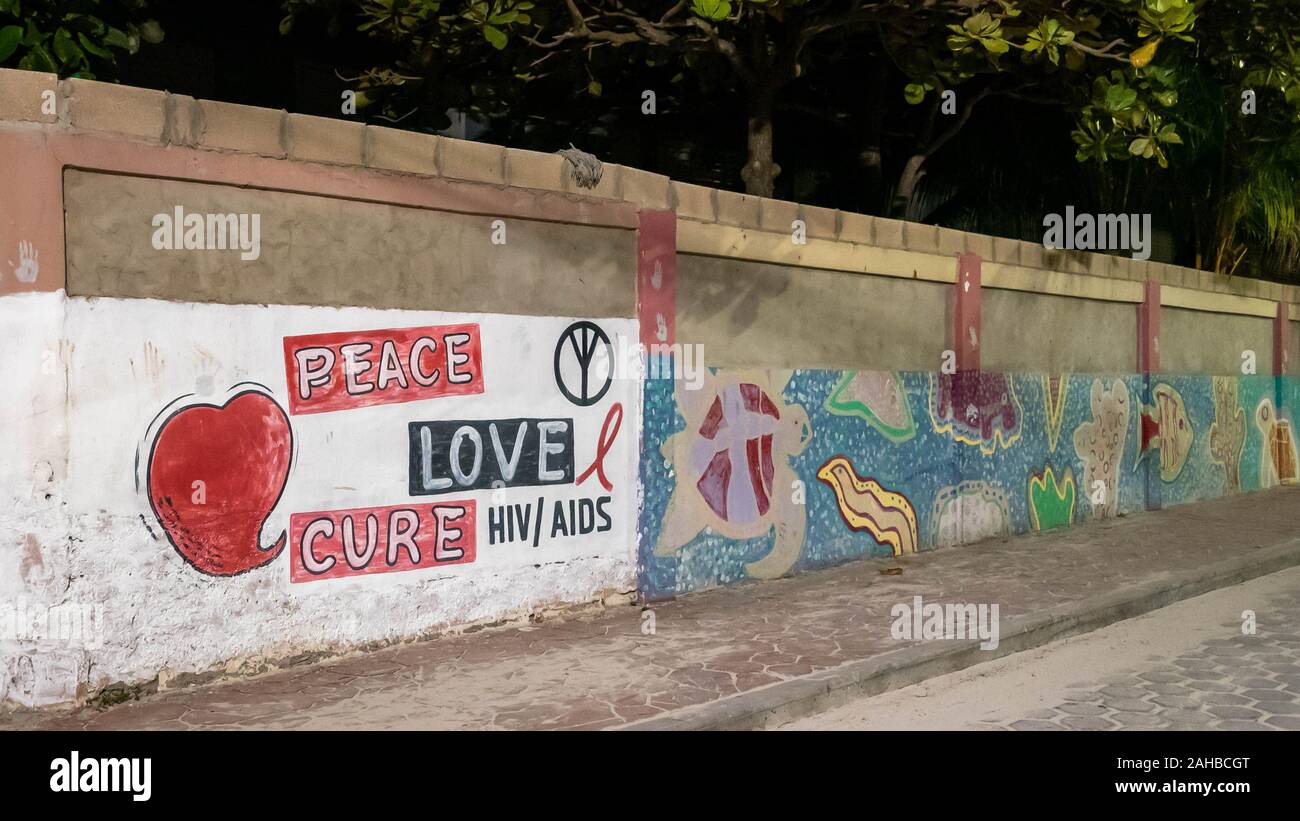 San Pedro, Ambergris Caye, Belize - November, 17, 2019. 'Peace, love, cure HIV/AIDS' graffiti mural painted on the stone wall in Belize. Stock Photo