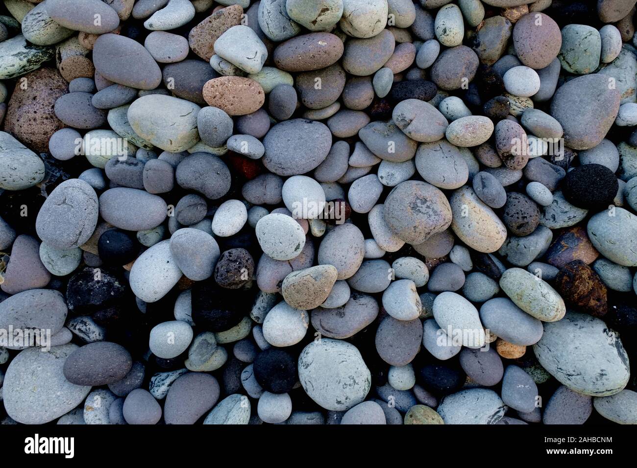 A collection of gray round stones, various sizes and shapes, various minerals, close view. Stock Photo