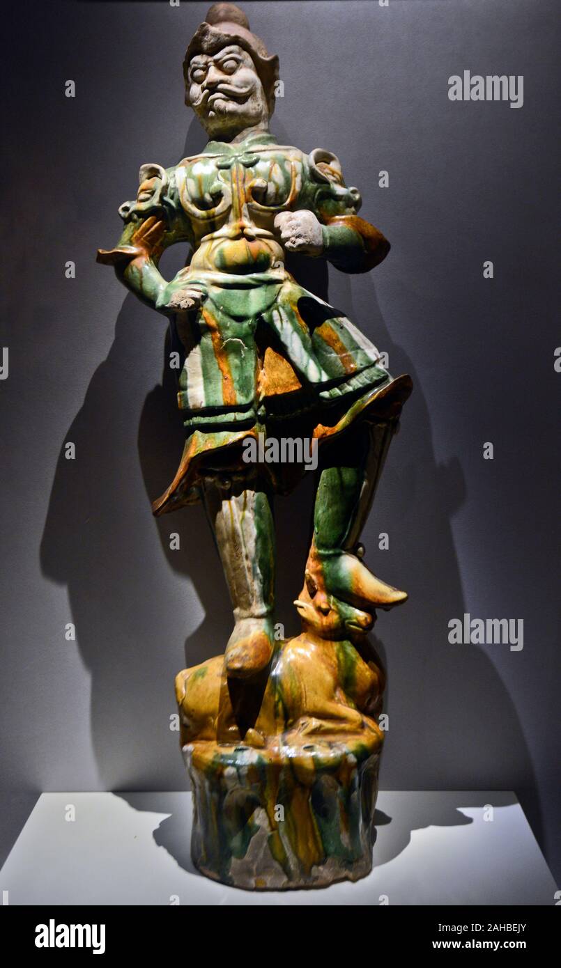 Chinese porcelain: Tricolor-glazed pottery figurine of Buddhist god Tianwang. Tang Dynasty (618-907 AD). Wuhan Museum, China Stock Photo