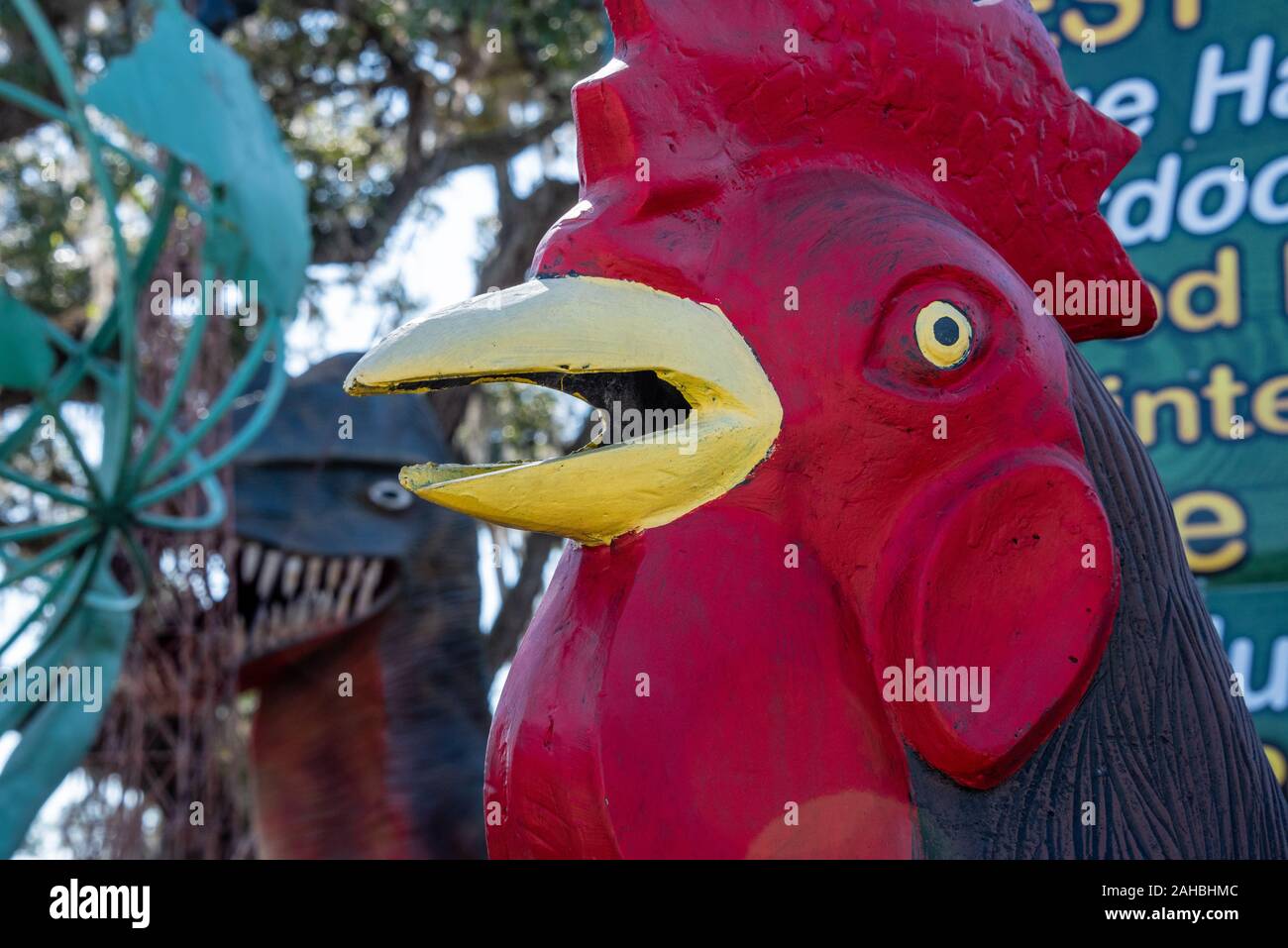 Giant cast aluminum rooster and dinosaur at Barberville Roadside Yard Art Emporium in Pierson, Florida. (USA) Stock Photo
