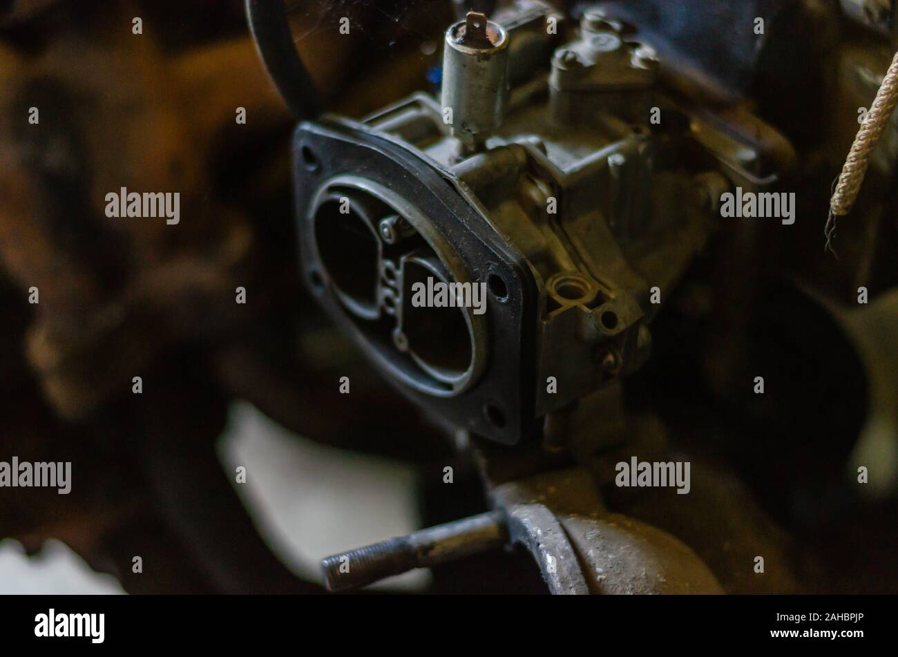 Old disassembled gasoline carburetor. Spare four-stroke gasoline engine. Close-up. Soft focus. The horizontal location of the picture. Stock Photo