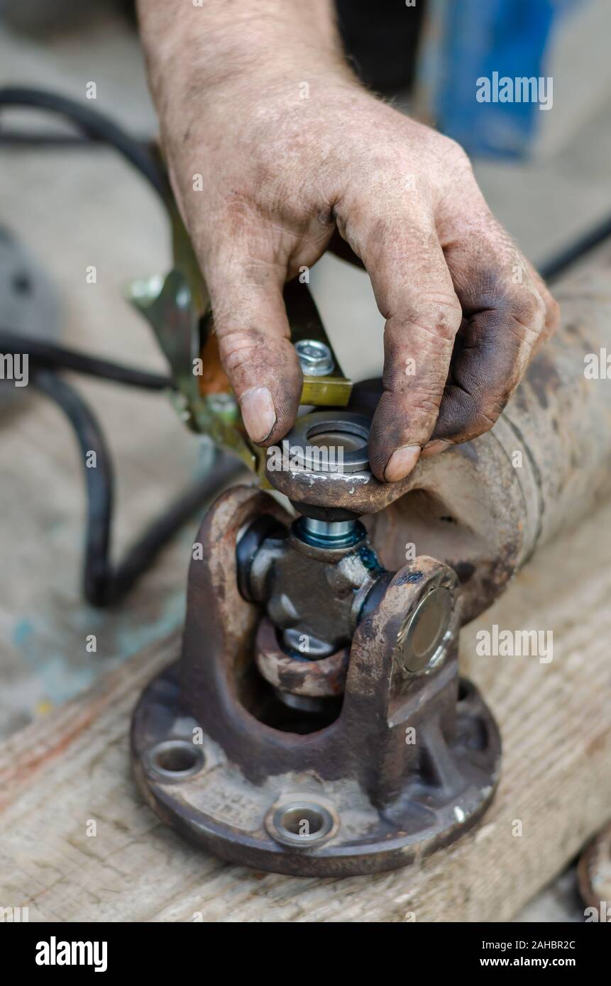 A man puts metal restrictive washers on the needle bearings of the