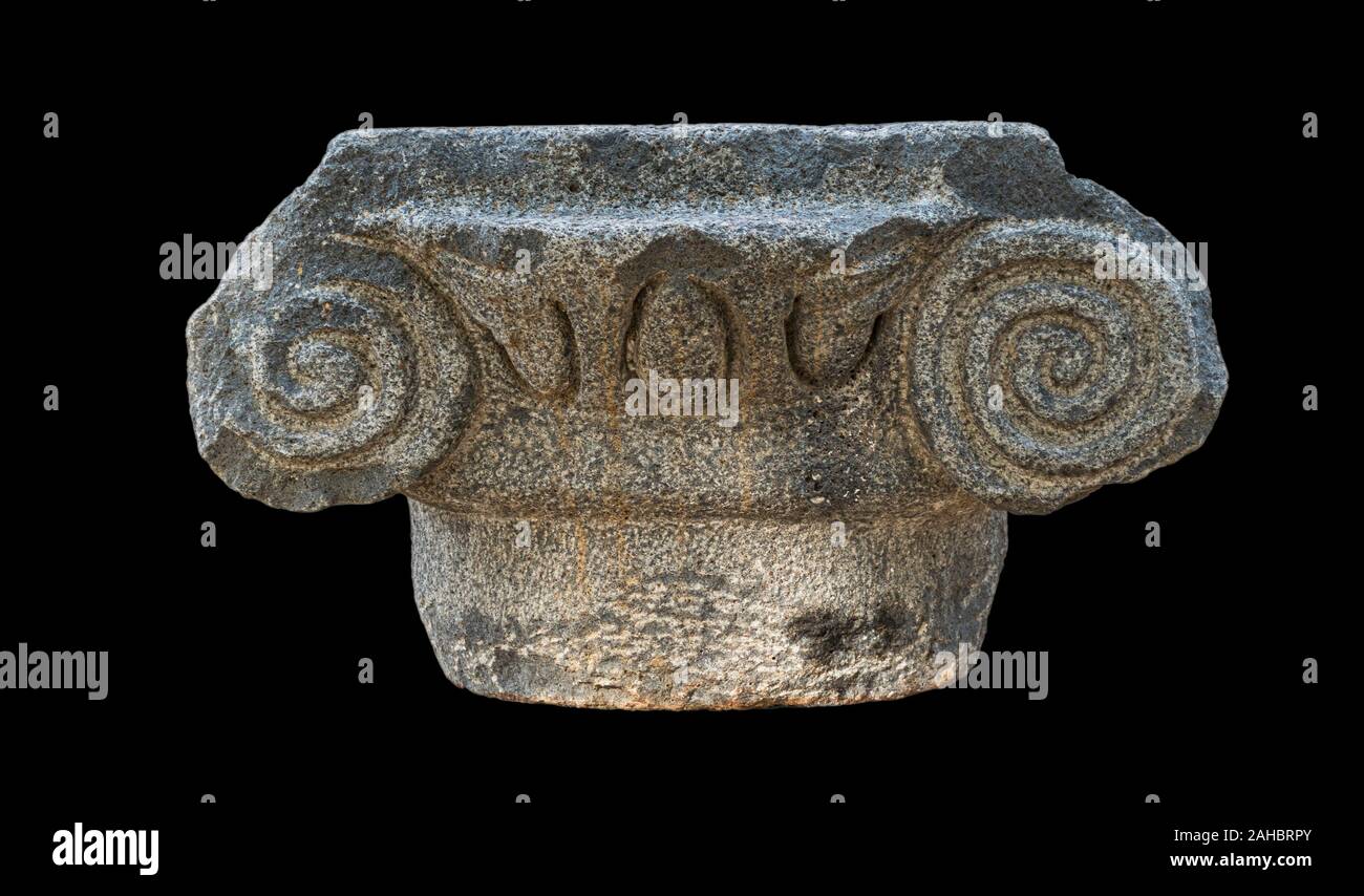 ancient greek ionic style basalt stone capital from the katzrin open air museum in the golan heights in israel isolated on a black background Stock Photo