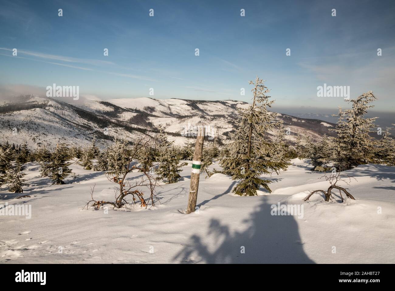 Beskid Slaski mountains with Skrzyczne hill and hiking trail sign in Poland during winter day with blue sky and few clouds Stock Photo