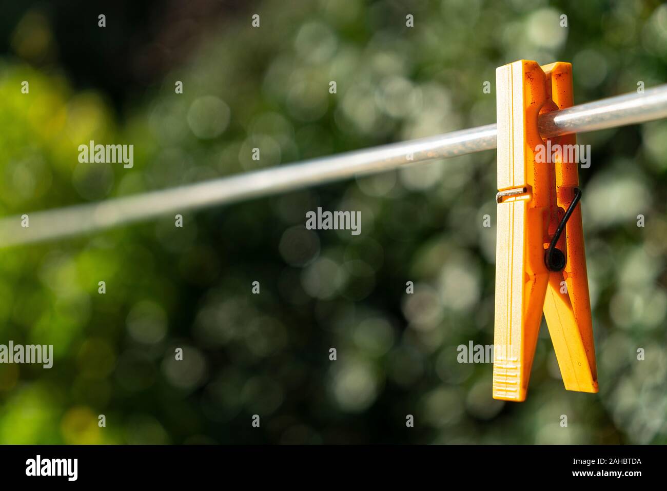 a clothespin hanging on a wire in the garden Stock Photo