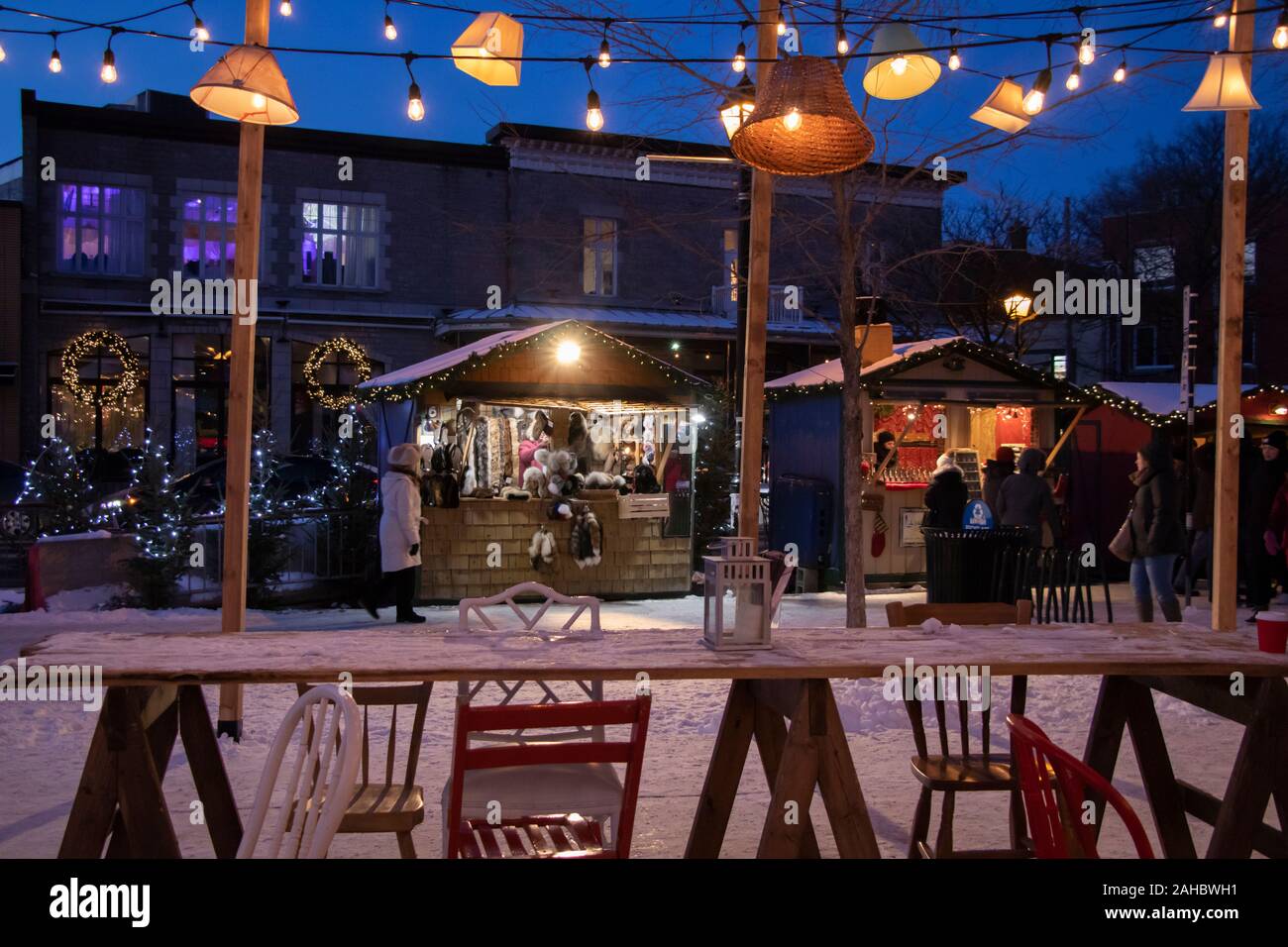 Longueuil, Québec, Canada - December, 7, 2019: Vendor Stands, antique chairs and table, String Lights Lamp Shades, Longueuil Christmas Market at night Stock Photo