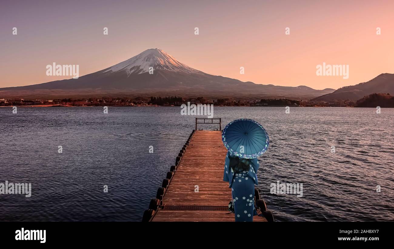 Girl with traditional dress look at Mount Fuji from Kawaguchi lake in evening Stock Photo