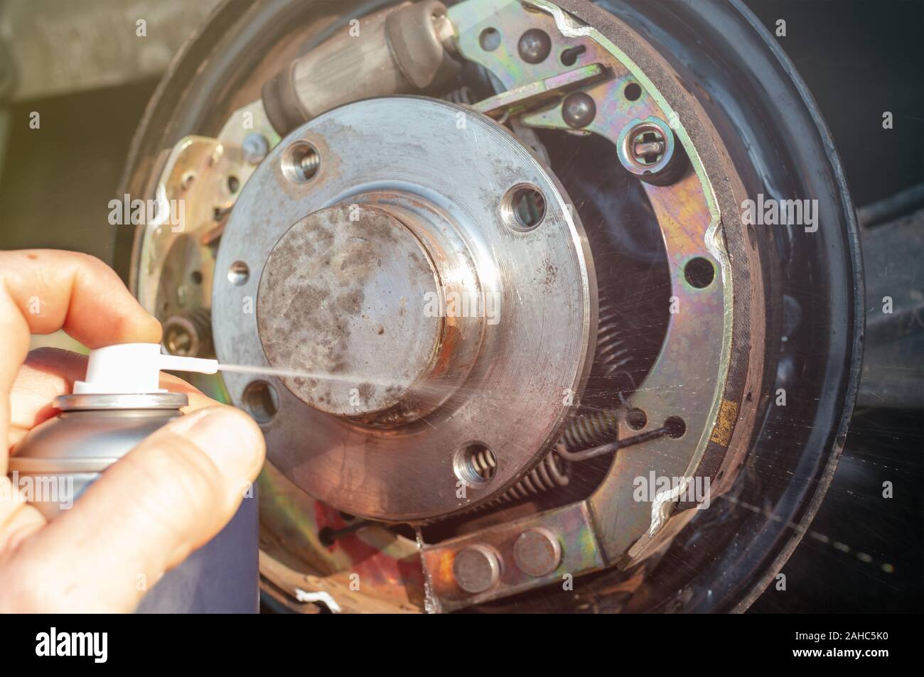 Car drum brake cleaning with spray Stock Photo