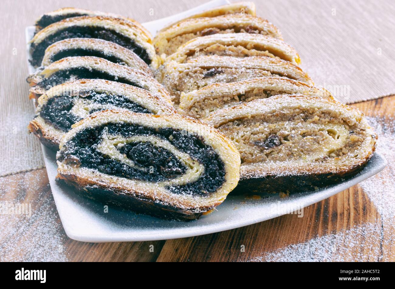 Poppy seed roll and wallnut roll on wooden table Stock Photo