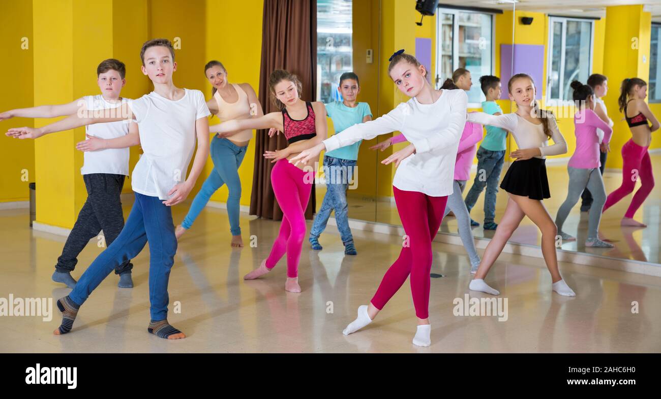 Group of children participating in dance class, following their teacher ...