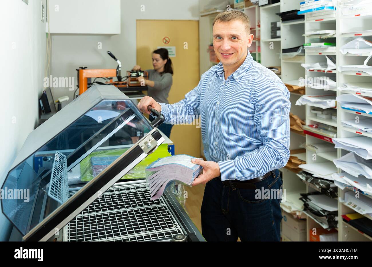 Worker packs notebooks in a vacuum packing Stock Photo