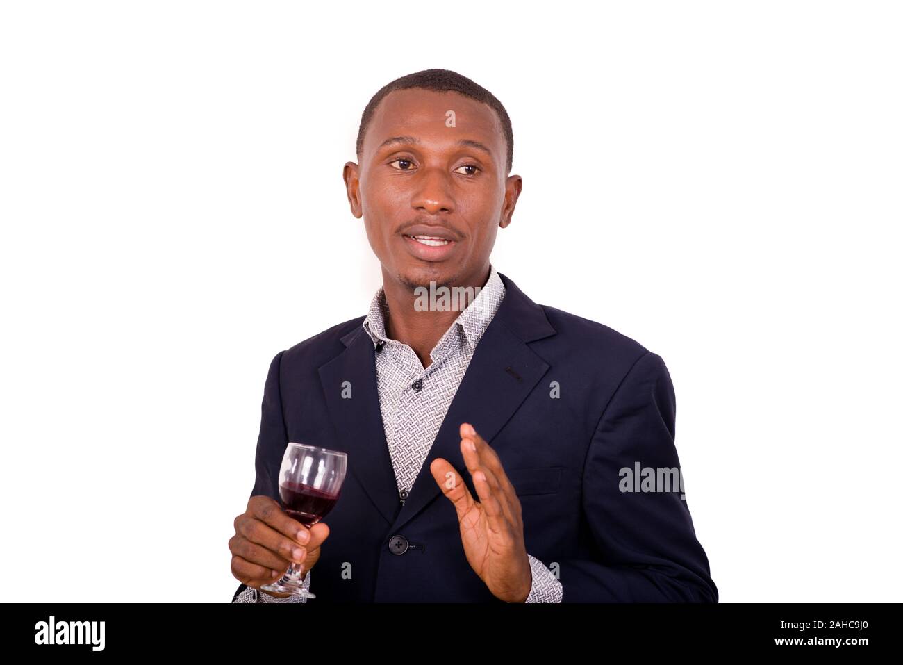 portrait of young happy businessman holding a glass of red wine ...