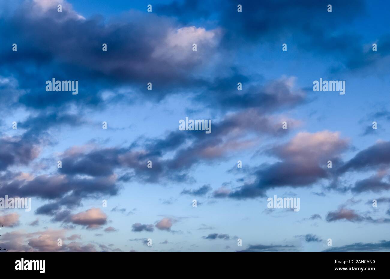 Beautiful and warm orange sunset clouds on a deep blue sky Stock Photo ...