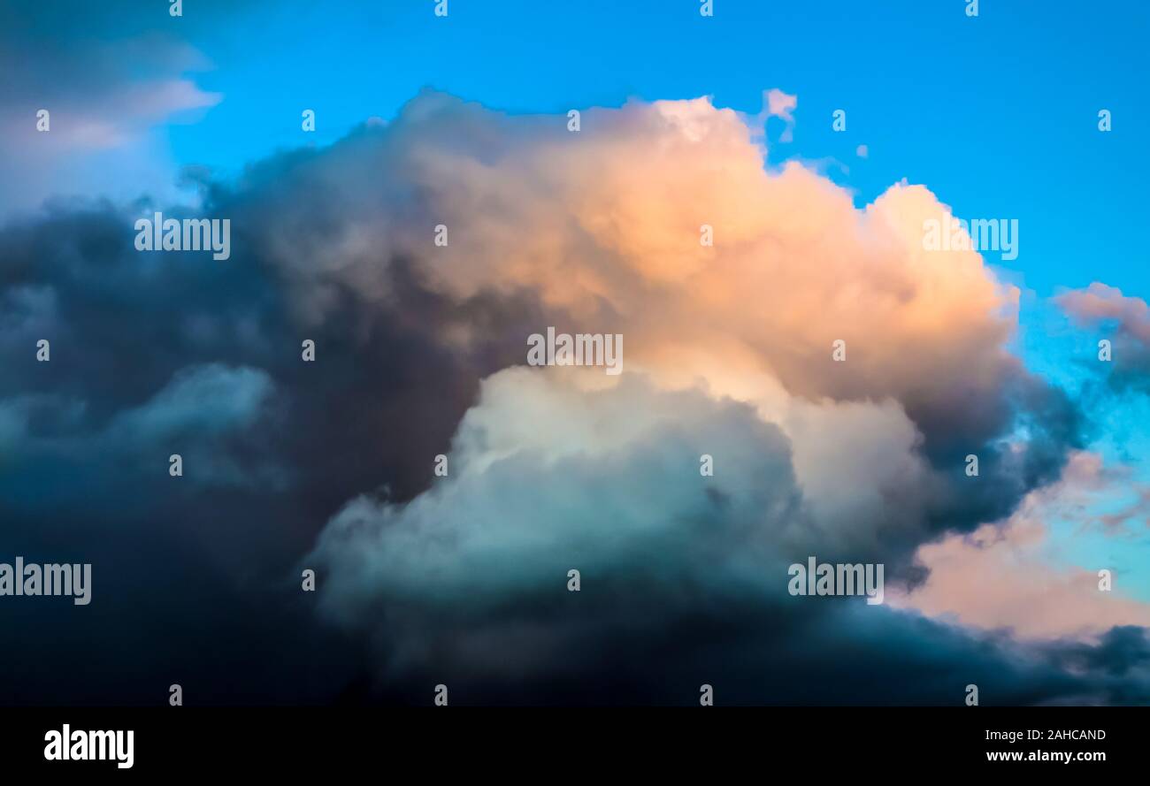 Beautiful and warm orange sunset clouds on a deep blue sky Stock Photo ...