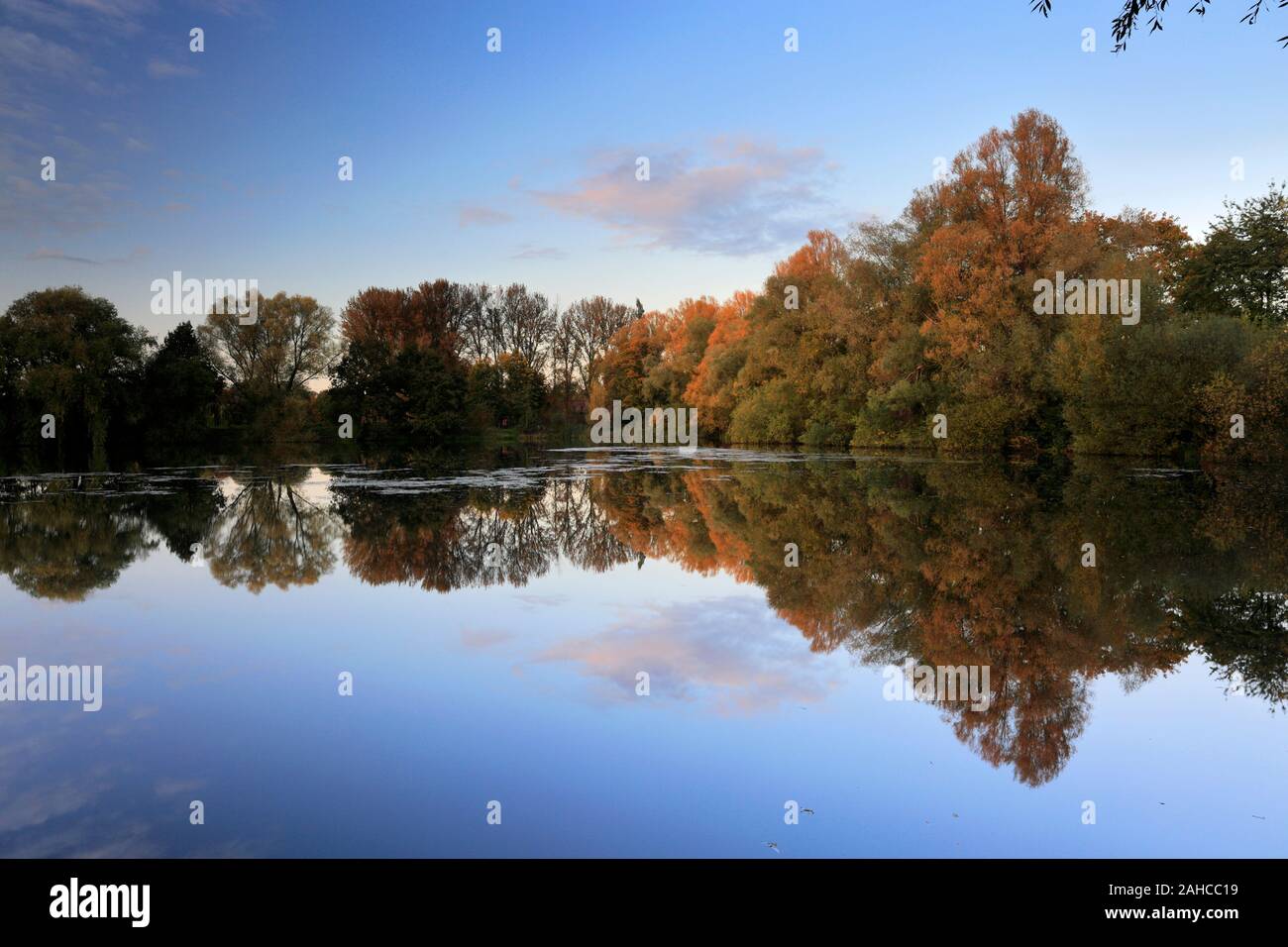 Autumn colours over the lake at Barnwell Country Park, Oundle town