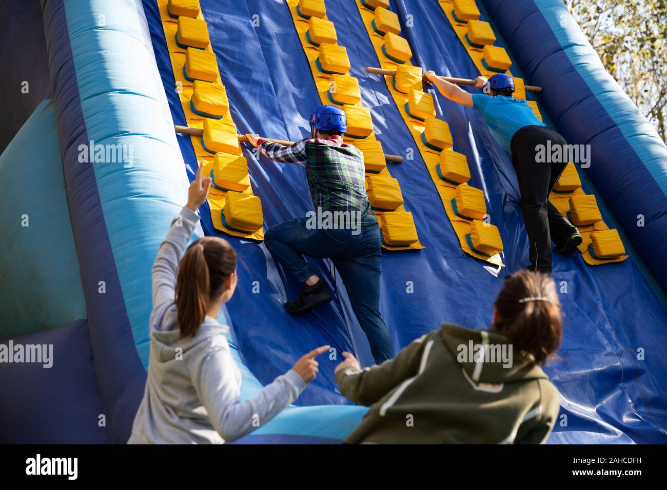 Group of enthusiastic men and women passing obstacles and having fun on ...