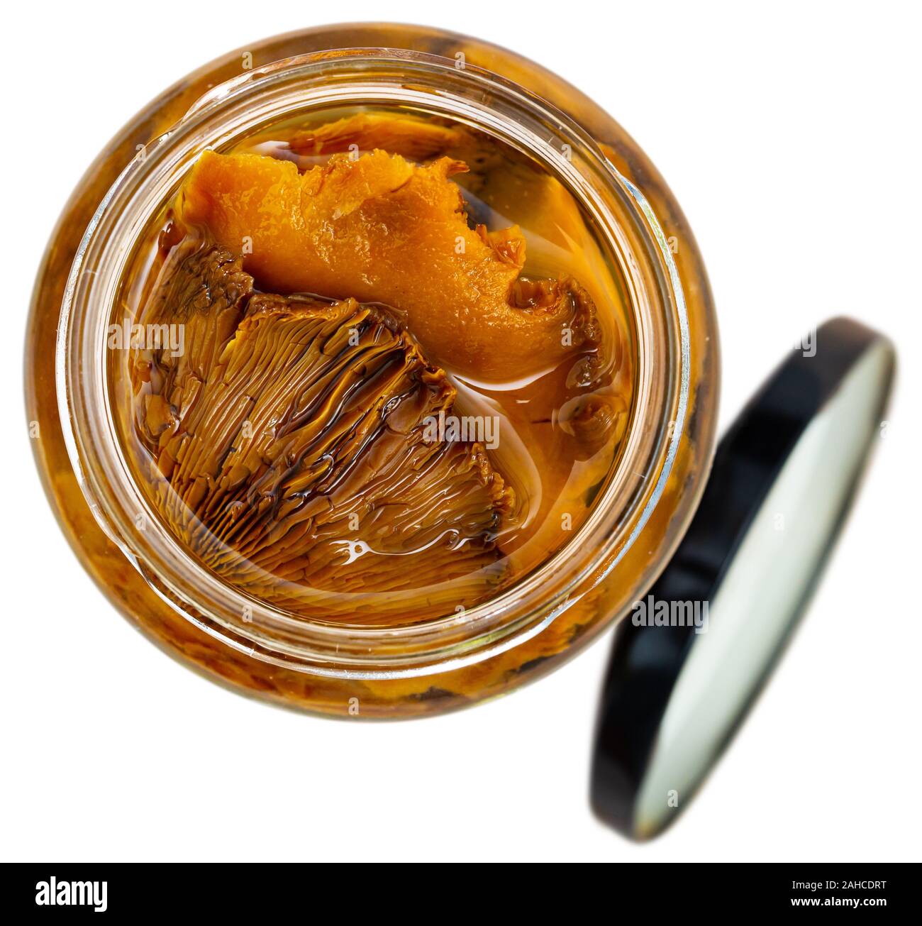 Closeup of chopped marinated forest mushrooms lactarius deliciosus in glass jar. Homemade pickles. Isolated over white background Stock Photo