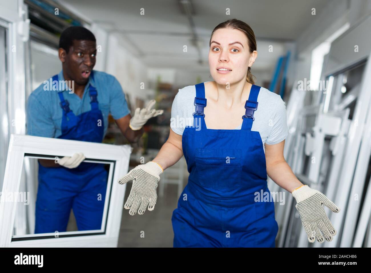 Two masters are conflicting in time working with window frame in the window workshop. Stock Photo