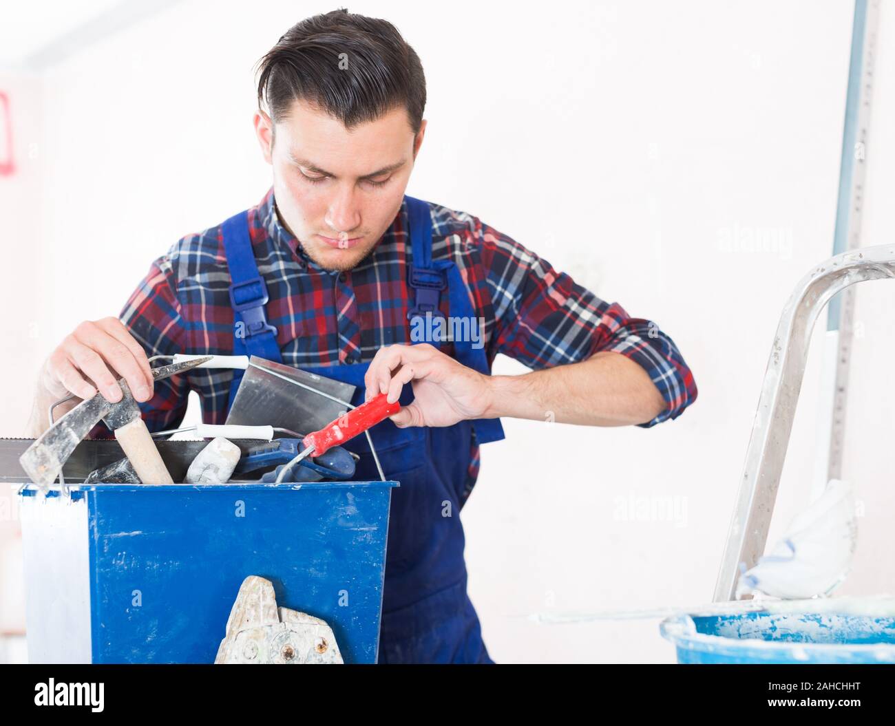 Handyman searching in his toolbox for necessary tools Stock Photo