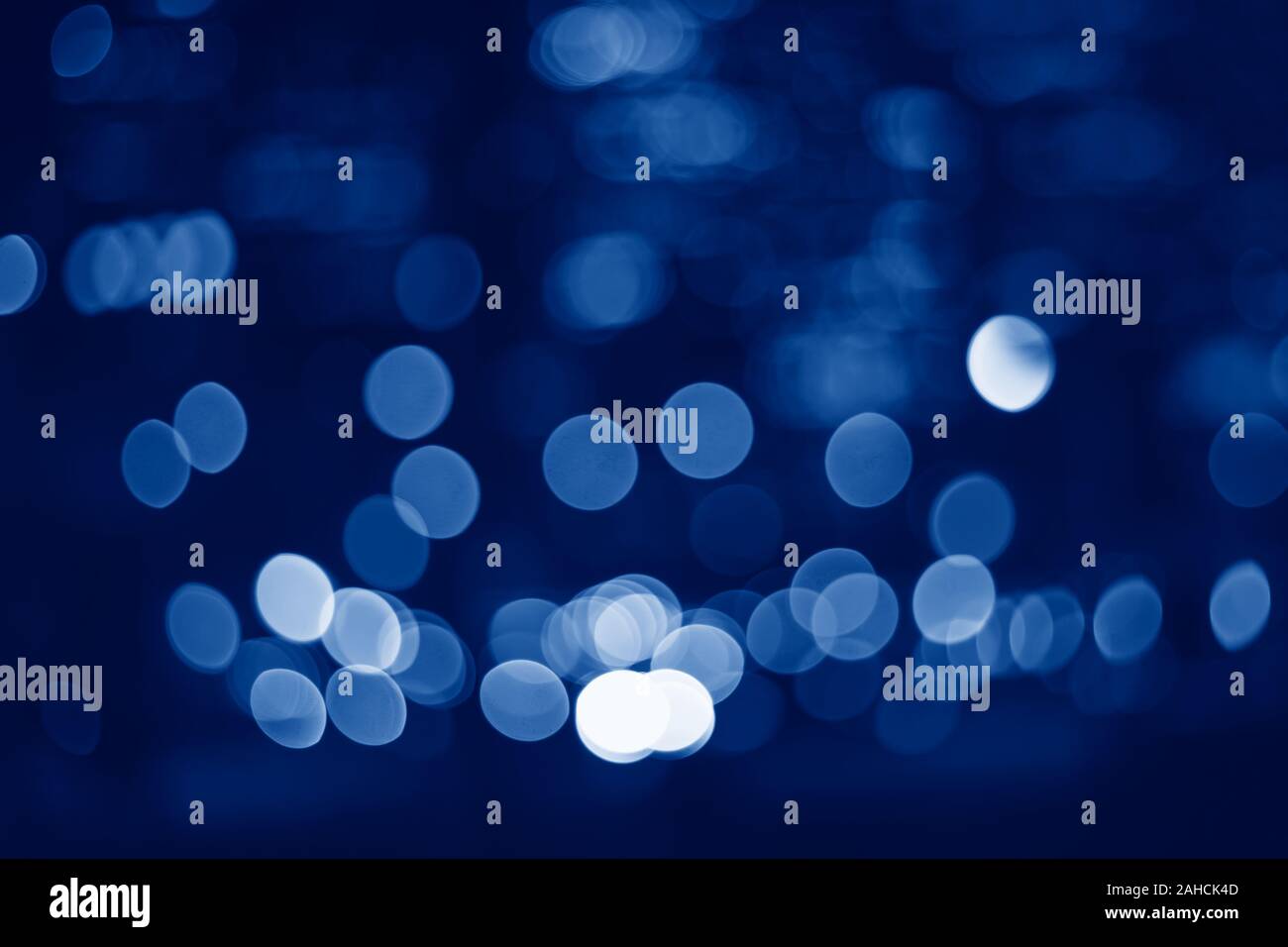 Abstract sparkling colorful blurry background bokeh. Classic blue 2020 year trend color backdrop wallpaper. Cinematic effect, evening night street rom Stock Photo