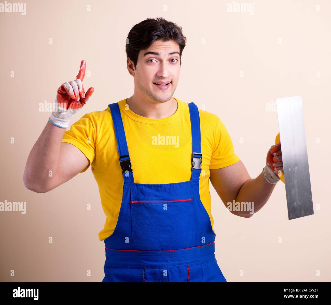 The young contractor employee applying plaster on wall Stock Photo