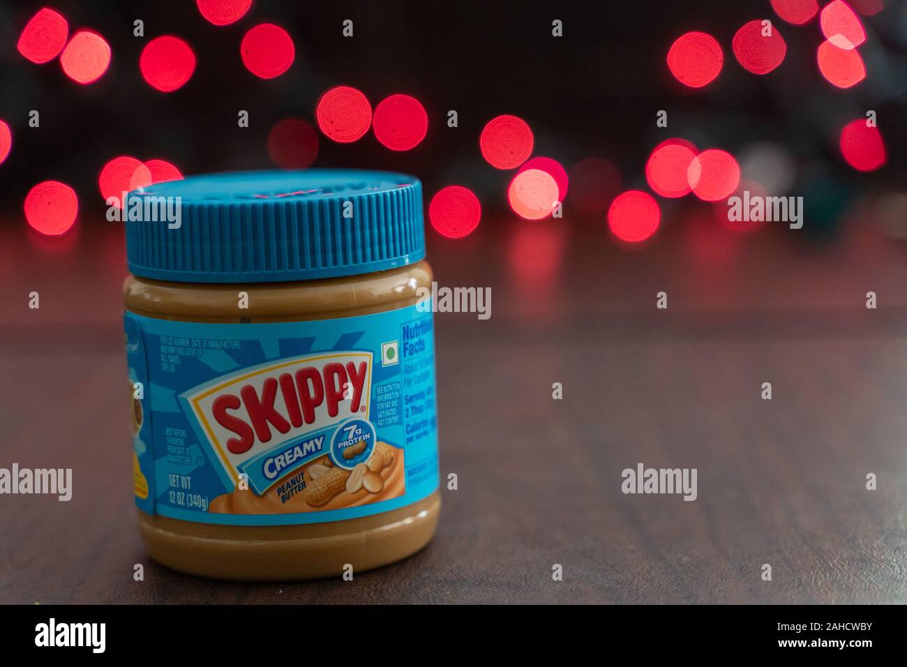 Minneapolis, Minnesota - December 23, 2019: Skippy brand peanut butter sitting on a table, red bokeh balls in the background Stock Photo