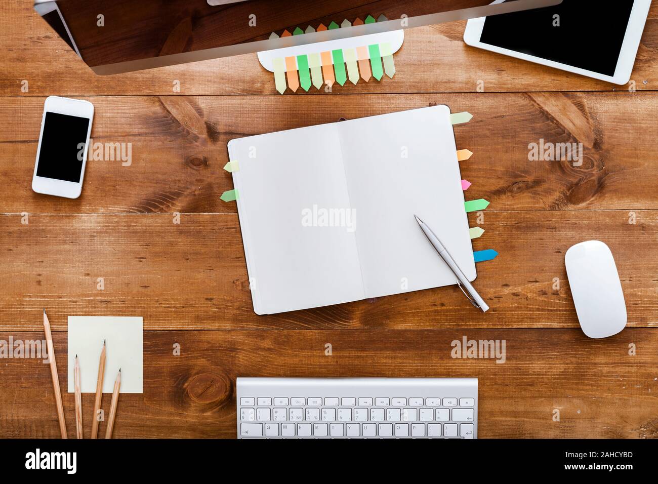 Modern table with notebook organizer and computer monitor on brown wooden desk Stock Photo