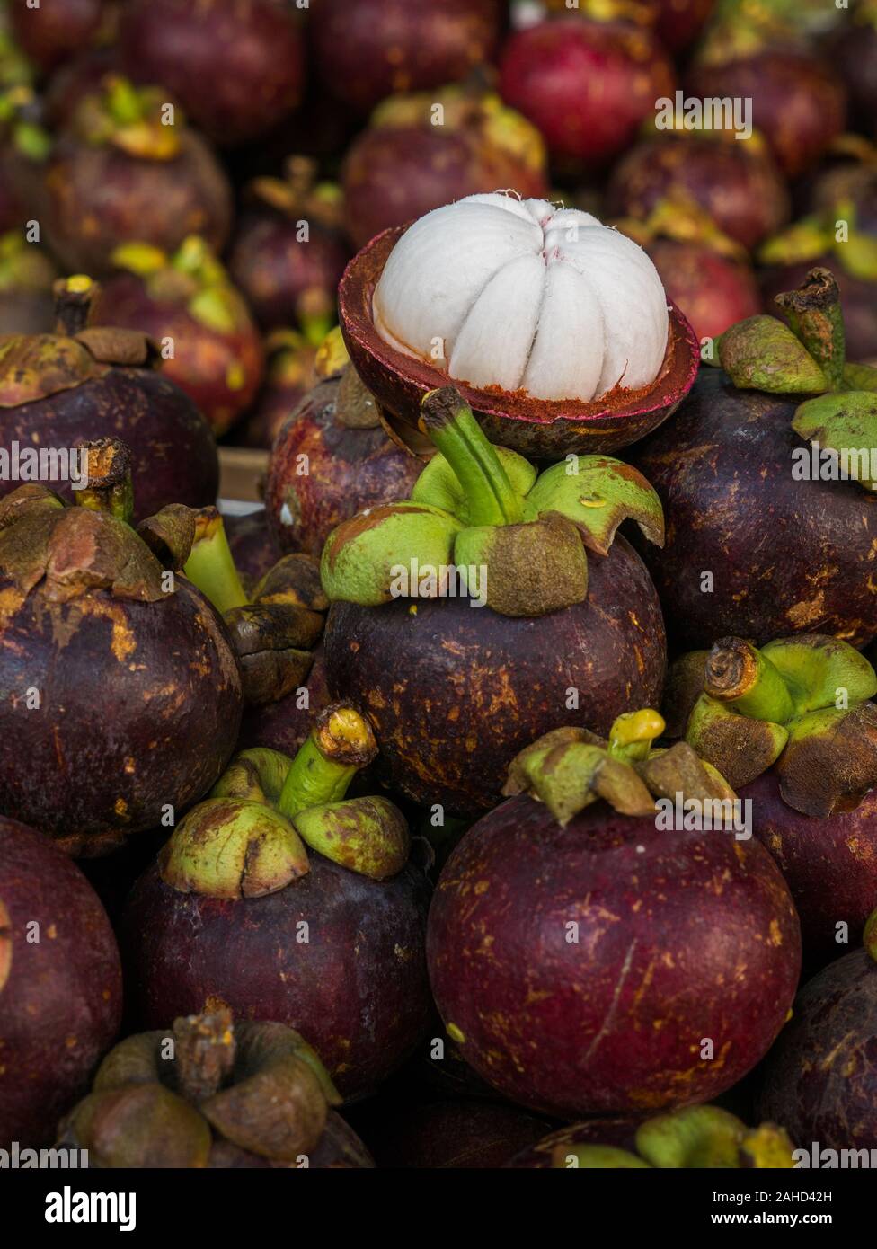Various purple and fresh mangosteen, closed and peeled, filling the frame, close-up Stock Photo