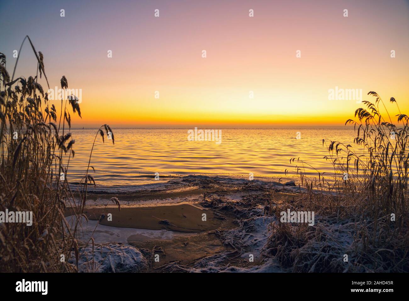 The first rays of the sun over lake Ladoga in the morning in winter. Leningrad region . Stock Photo