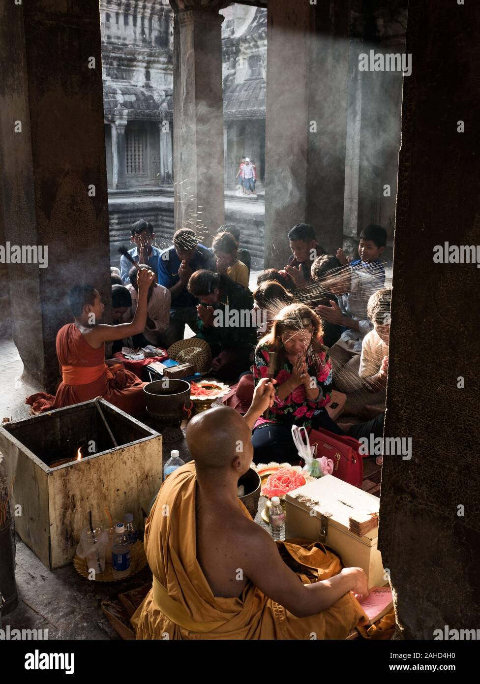 Picture of blessing ceremony with of Buddhist monk splashing holy water believer's heads on Visak Bochea day (Budda's birth), Angkor Wat, Cambodia Stock Photo