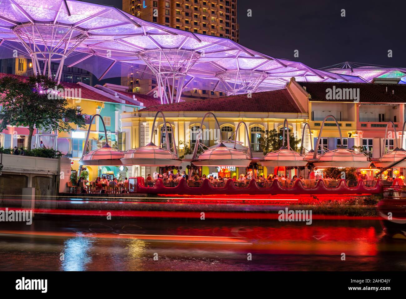 Singapore River at night, colourful restaurants at the quay, hip party quarter of Clarke Quay, oversized umbrellas covering the passage, at night, Sin Stock Photo