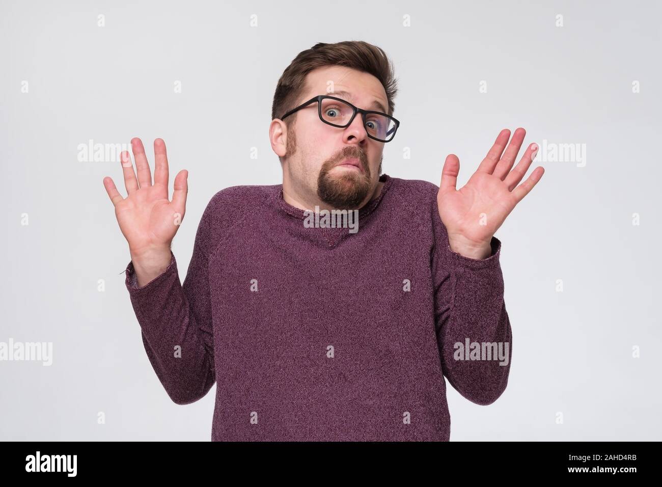 Doubtful young man in glasses gesturing with hands denying to participate in your business. Stock Photo