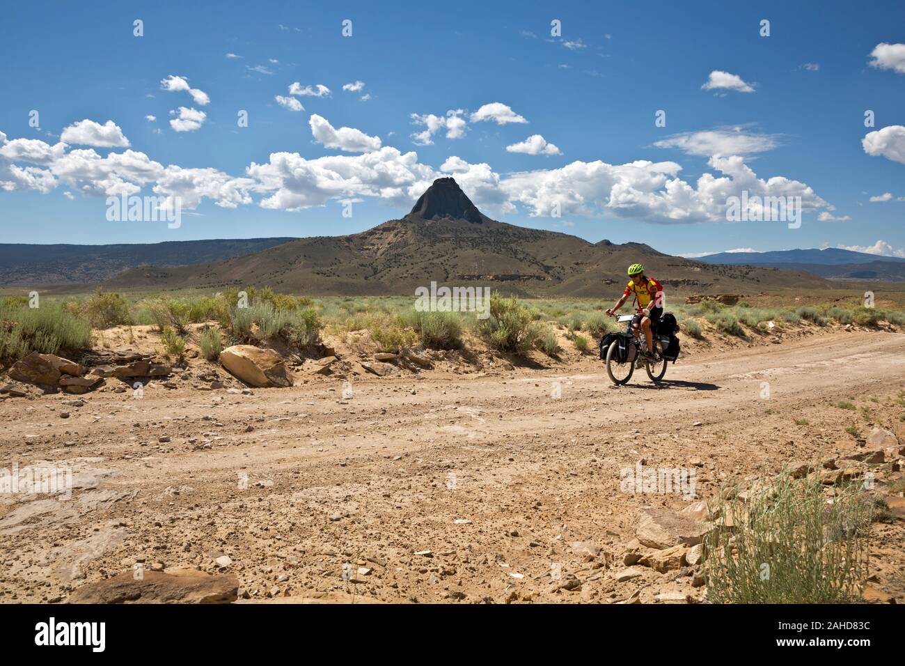 NM00220-00...NEW MEXICO - Cycling pass a volcanic plug, standing tall above the dry prairie lands along the Great Divide Mountain Bike Route. Stock Photo