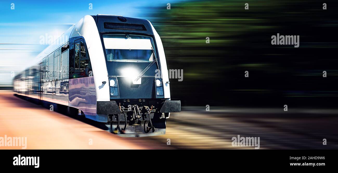 Modern train moving fast on a rail tracks in a blurred motion on with copy space. Stock Photo