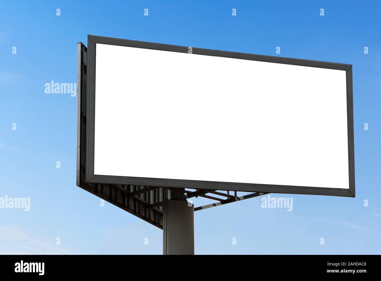 Template of a large blank advertising billboard on a clear blue sky background. Stock Photo