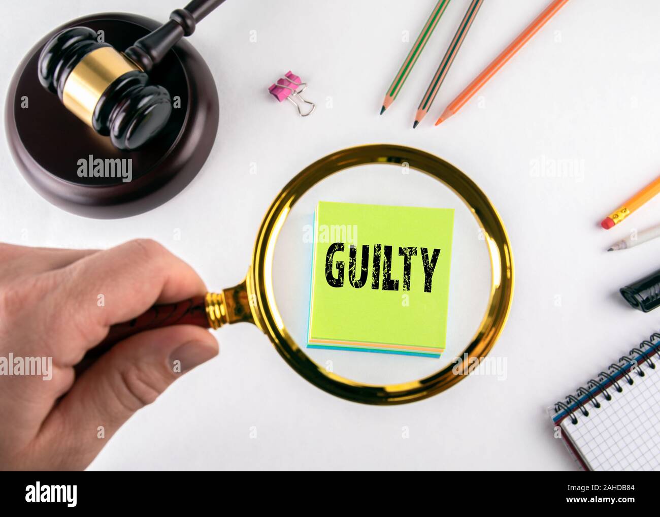 Guilty. Fair trial, law, lawyers and ethics concept. Man's hand, holding magnifying glass Stock Photo