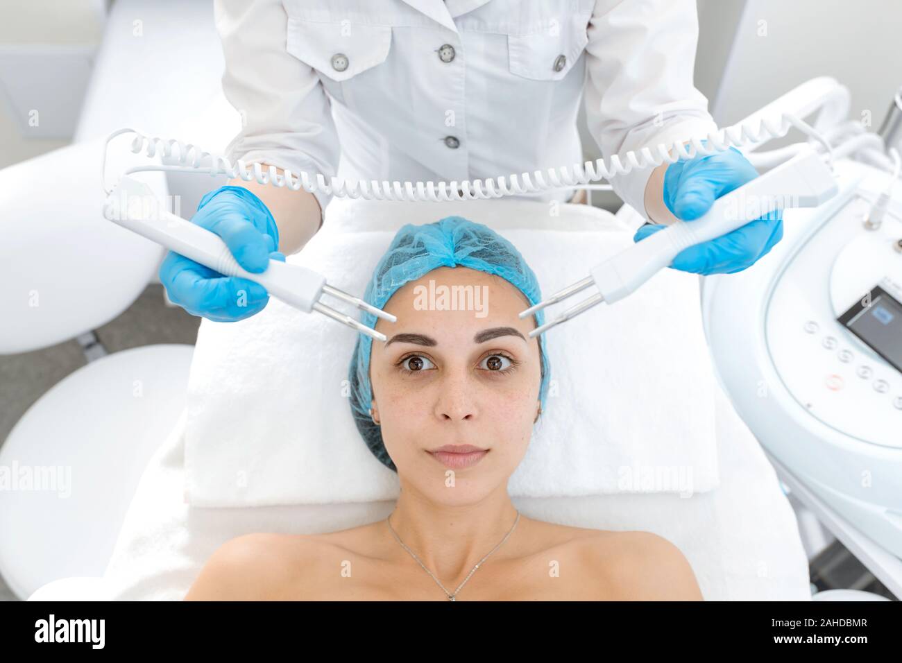 Portrait of a young beautiful girl face microcurrent therapy procedure