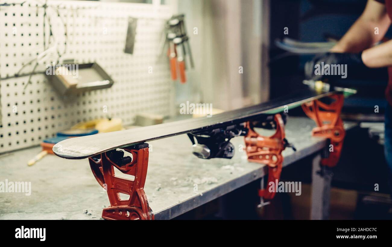 Male worker of ski service doing sharpening and repair of skis