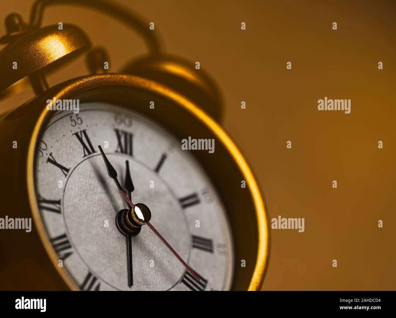 Golden vintage alarm clock showing five to twelve Stock Photo