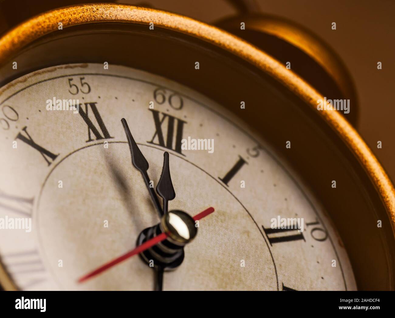 Golden vintage alarm clock showing five to twelve Stock Photo