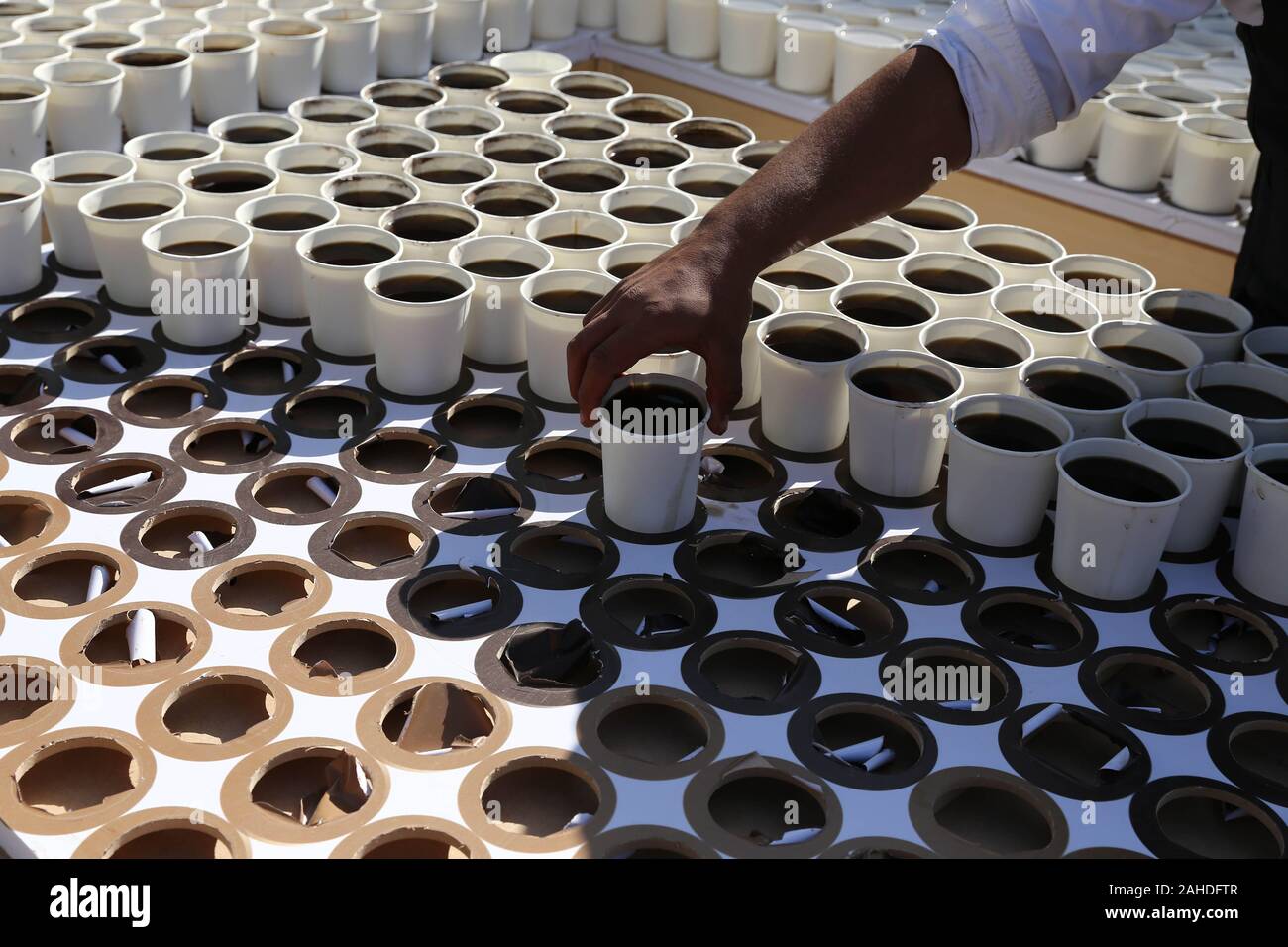 Giza, Egypt. 28th Dec, 2019. A man puts a coffee cup to create a mosaic of ancient Egyptian King